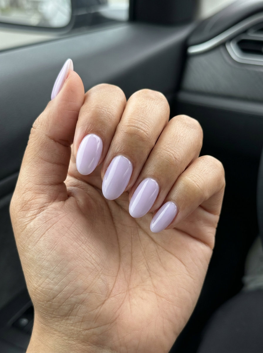 Milky lavender oval nails for wedding guest outfits in 2026. Elegant, opaque, cool undertone polish.