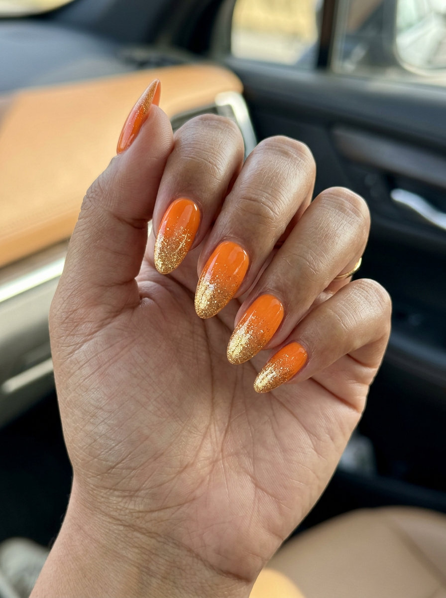 Sparkling Sunset Nails 2026: Festival Glam Sparkling sunset gradient orange nails with gold glitter for festival and summer vacation 2026.