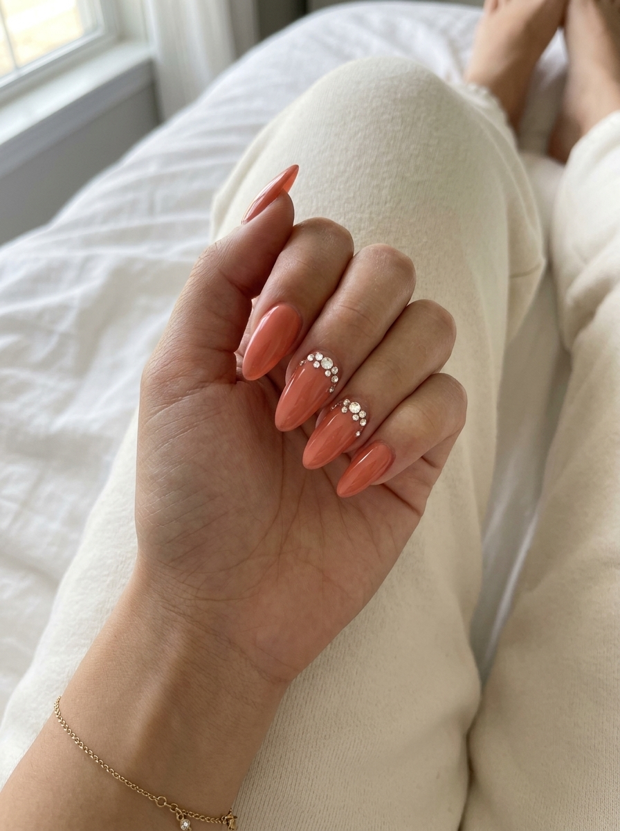 Romantic soft coral nails with clear rhinestone accents for summer dip nails 2026. Glamorous.