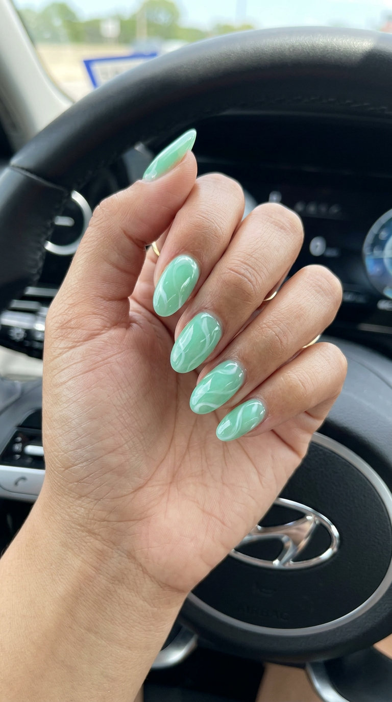 Mint green jelly swirl nails are a playful summer manicure color trend for 2026, perfect for casual outings.