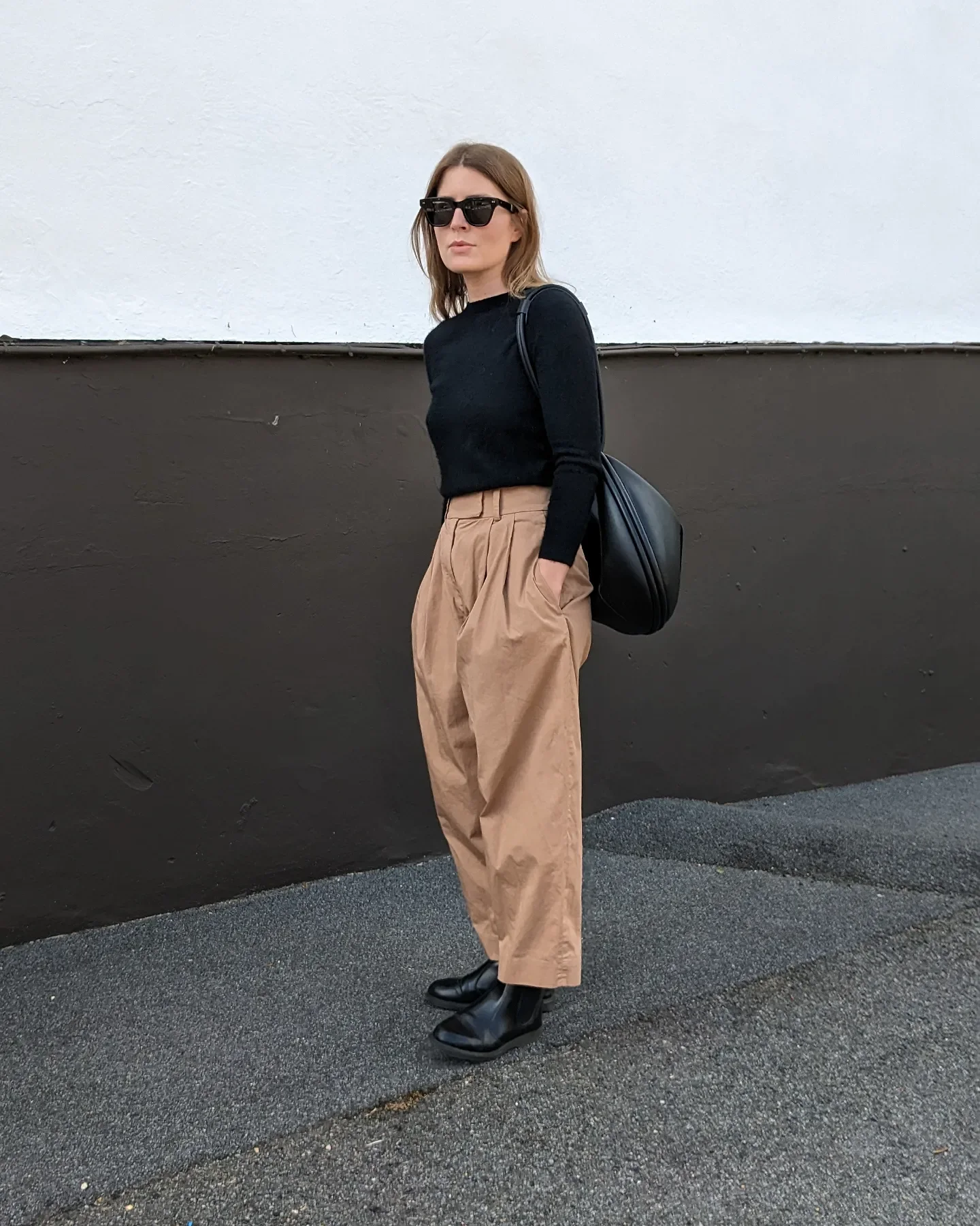 fall outfits with chelsea boots 2026 Minimal Black Knit With Tailored Camel Trousers