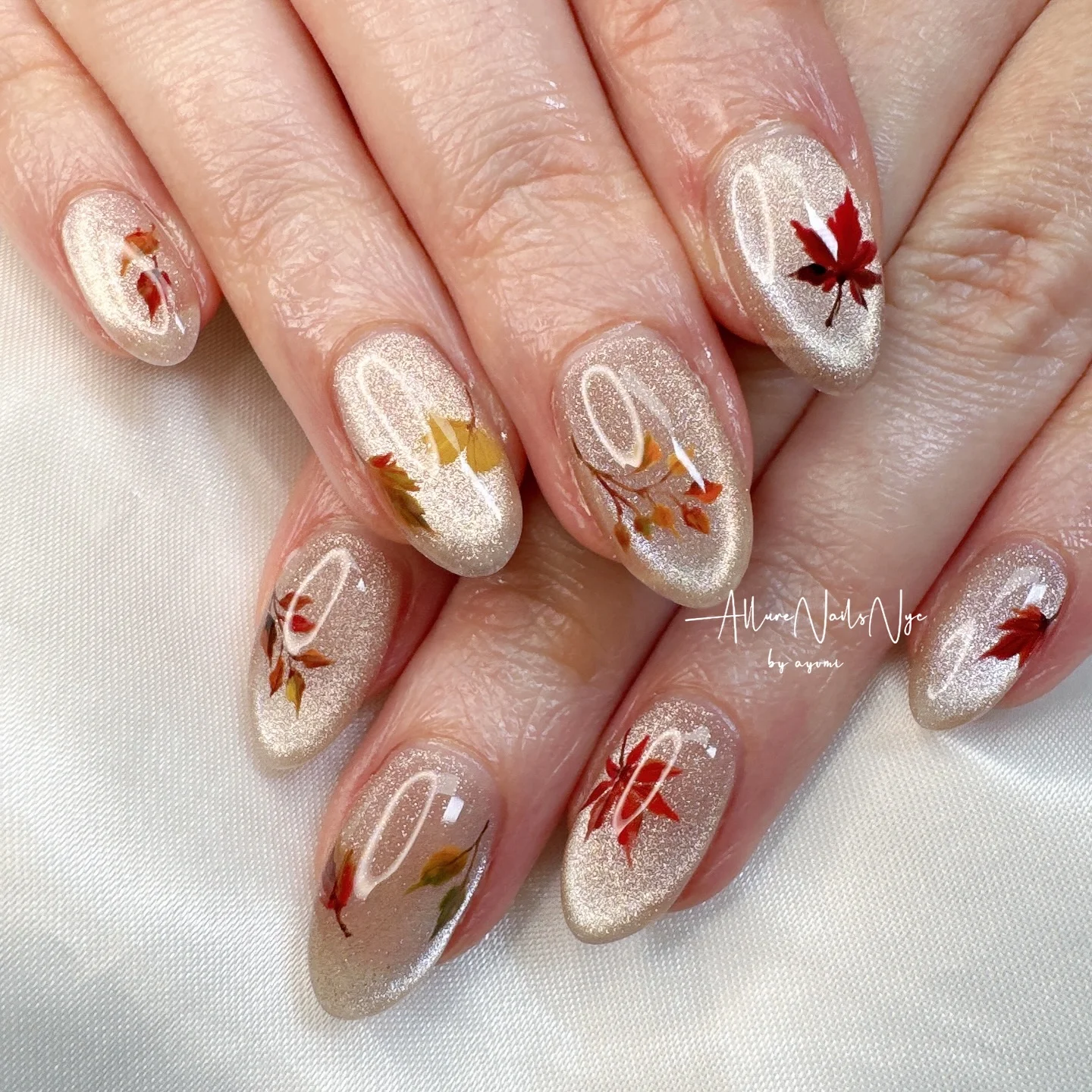 fall medium nail ideas 2026 Champagne Shimmer With Delicate Autumn Leaves