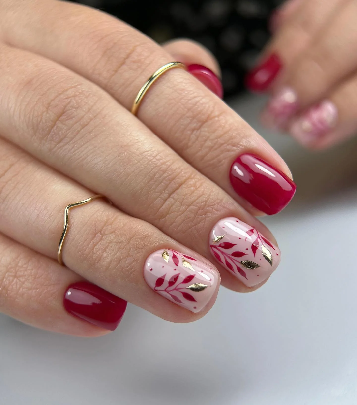 fall trendy nails 2026 Cherry Red Botanical Nails With Fine Gold Accents