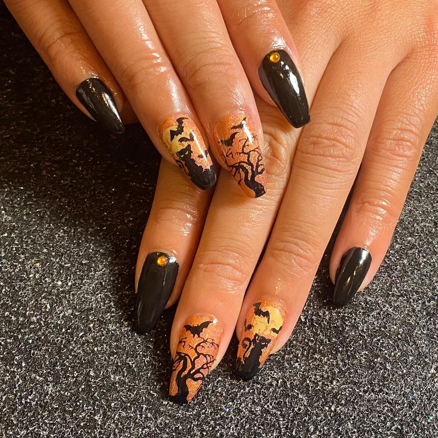 halloween nail art 2026 Black And Burnt Orange Nails With Haunted Silhouettes