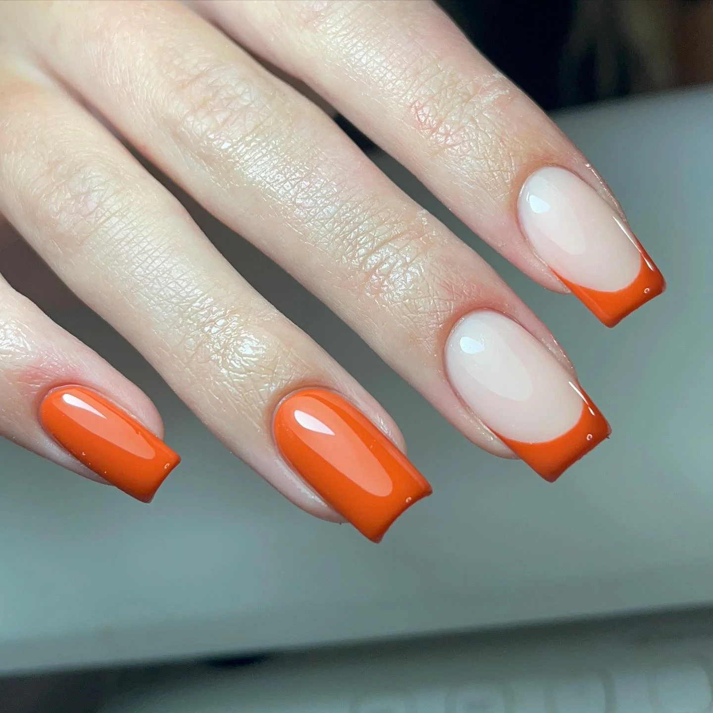 fall nails for pale skin 2026 Glossy Orange French Tips On A Milky Base