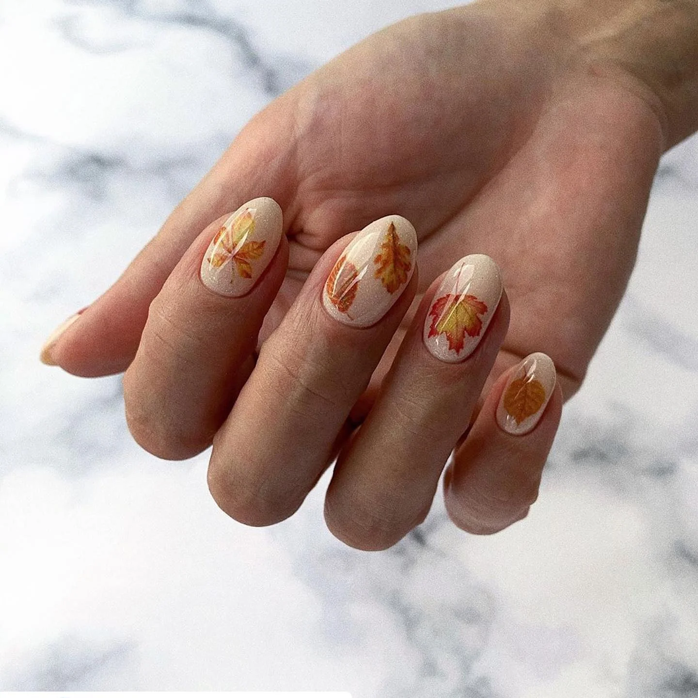 nude fall nails 2026 Creamy Nude Almond Nails With Tiny Autumn Leaves