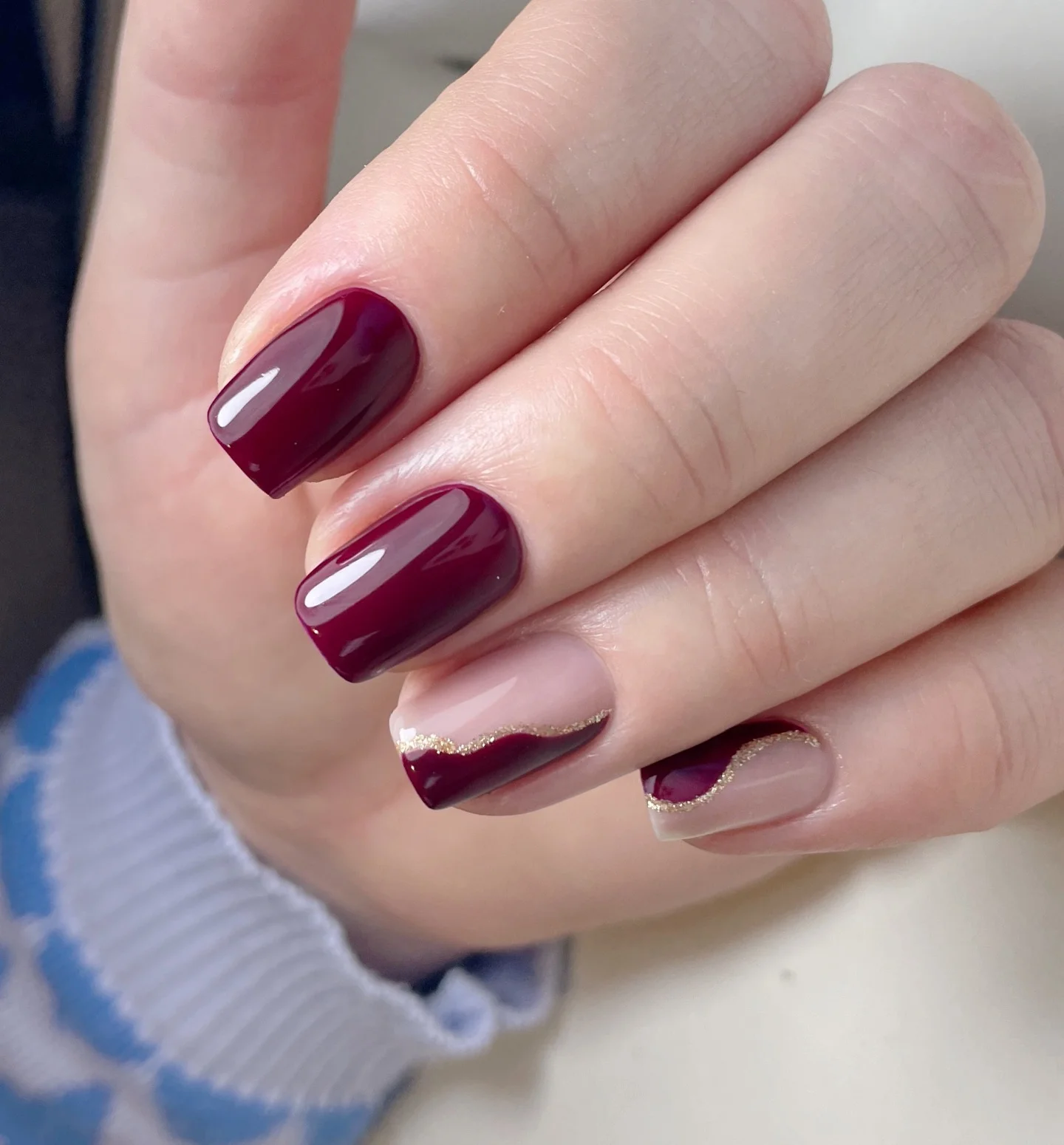 maroon fall nails 2026 Short Burgundy Nails With A Curved Gold Detail